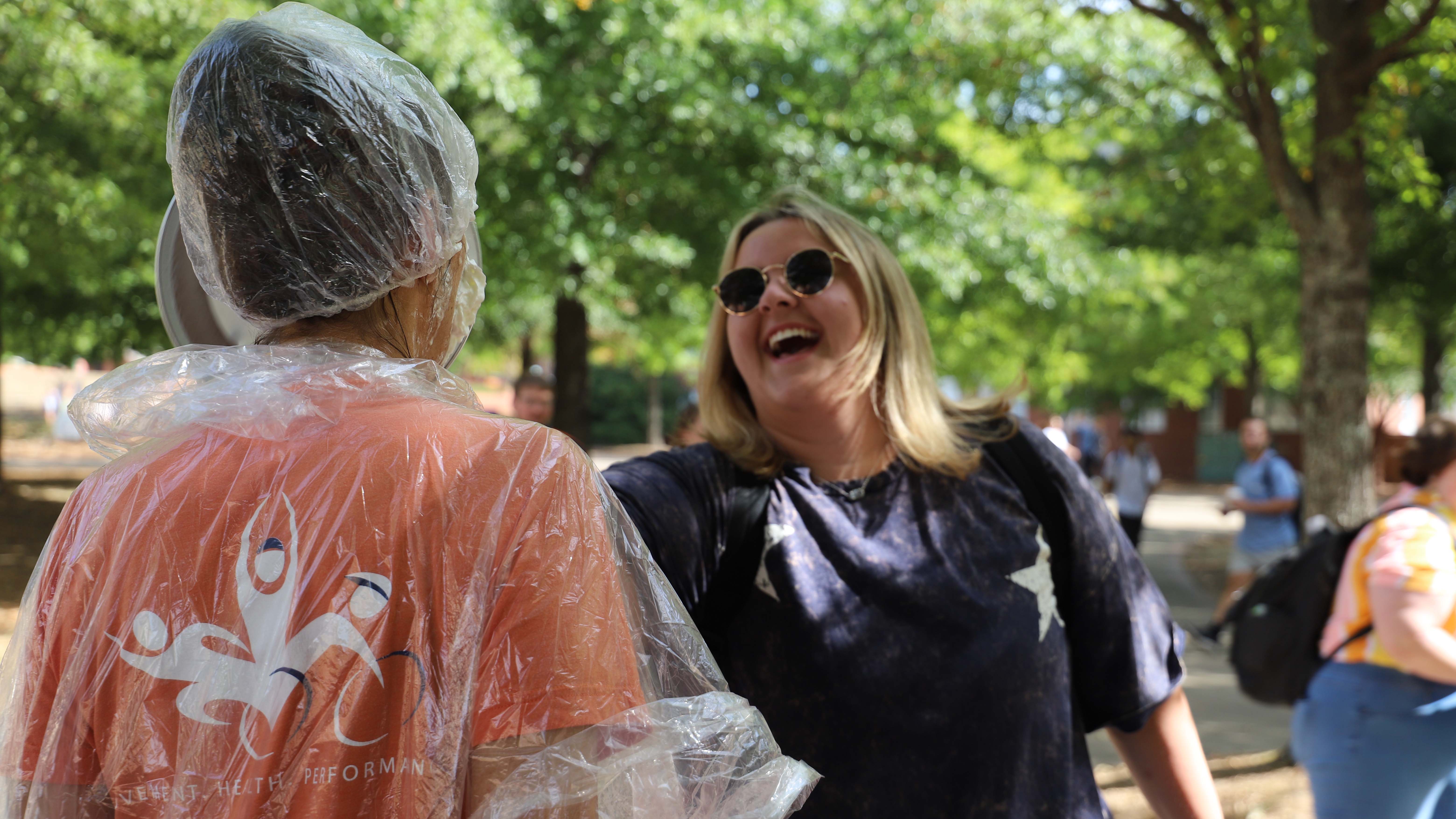 A student throws a pie at a professor
