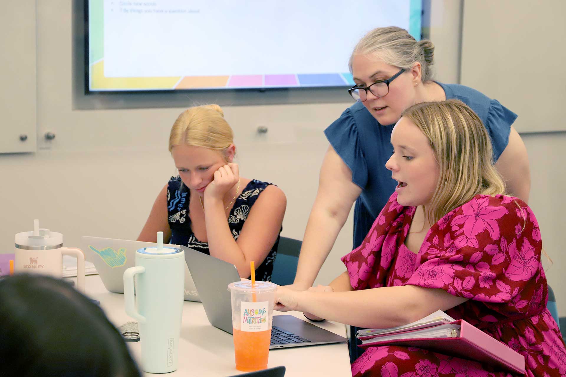 Dr. Baumann works with a student in a classroom.