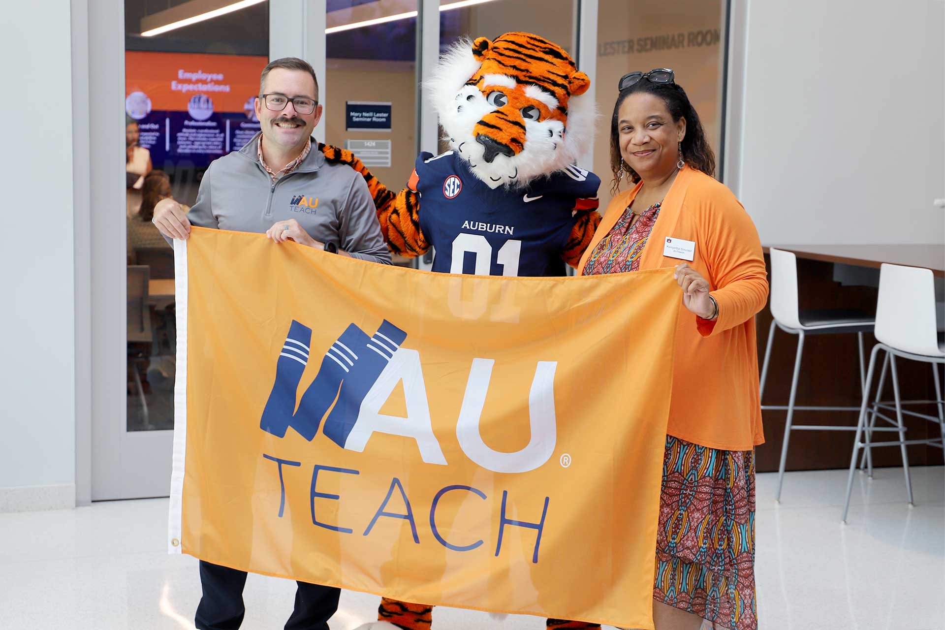 College of Education faculty members hold up an AU Teach flag.