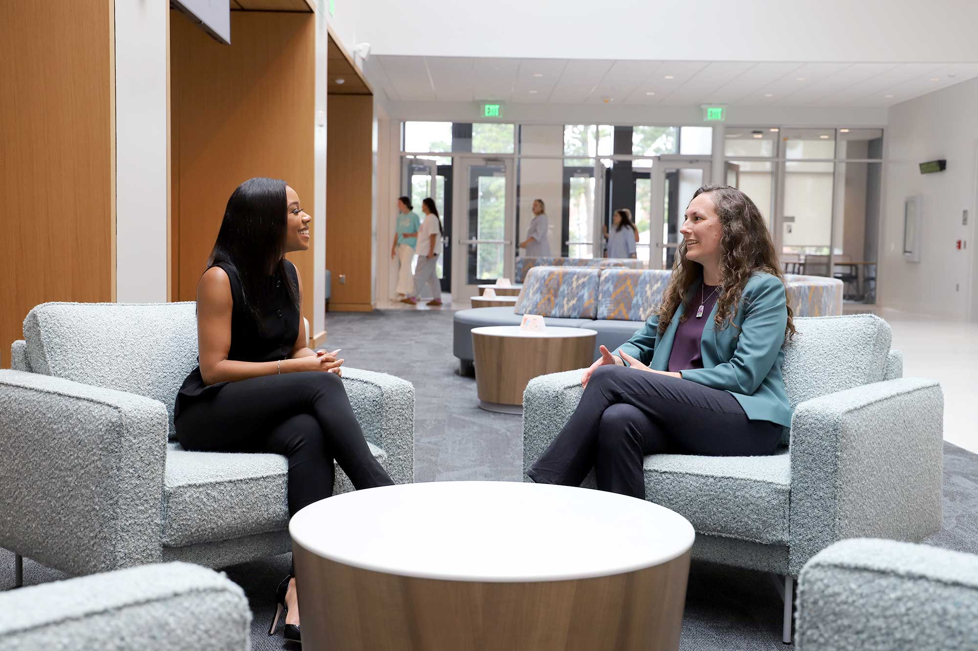 Dr. Cornish speaks with one of her students in the commons of the college of education building.