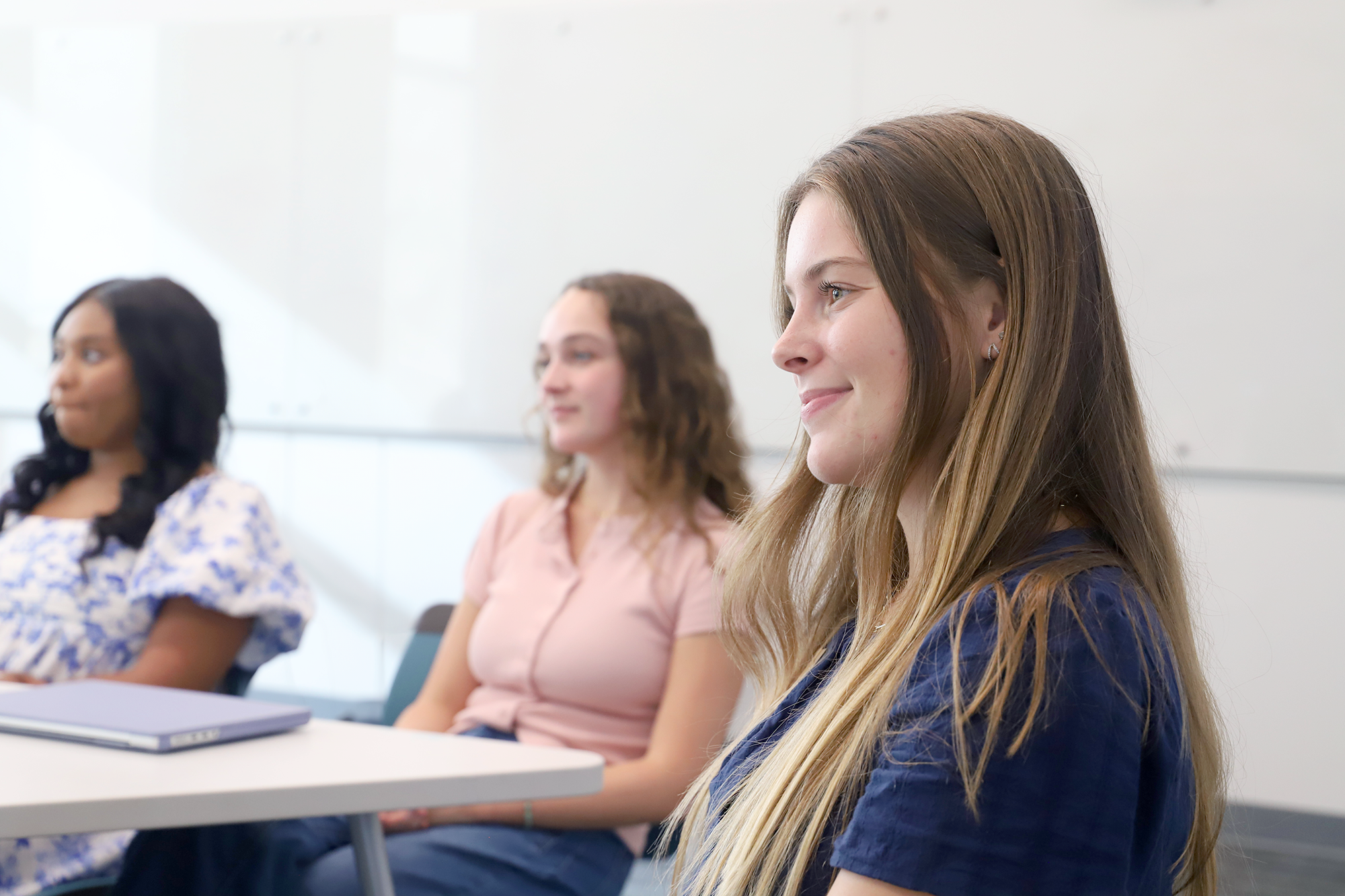 Students listen in a classroom setting.