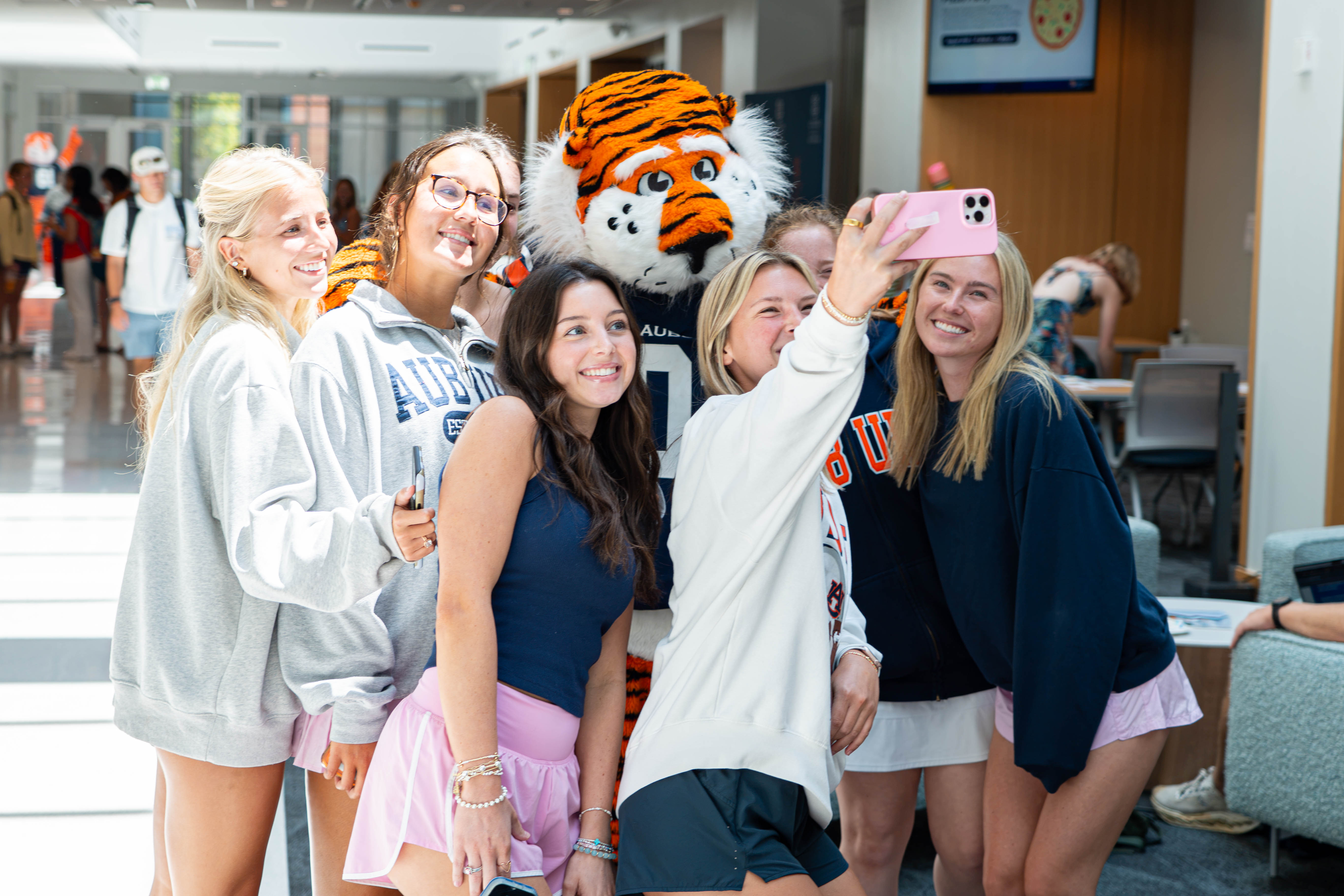 Students take a selfie with aubie in the college of education building.