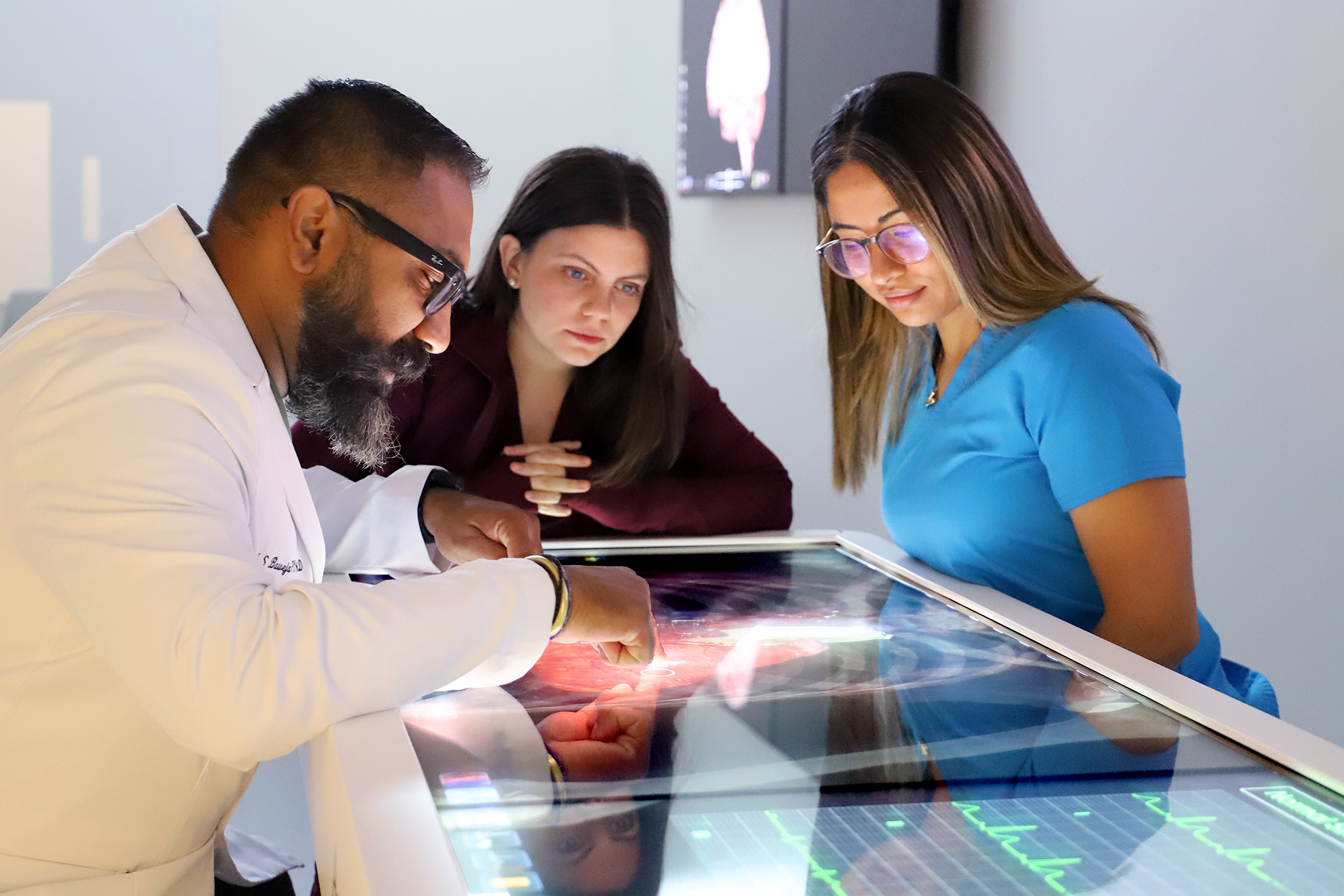 Dr. Baweja works with a student over a table