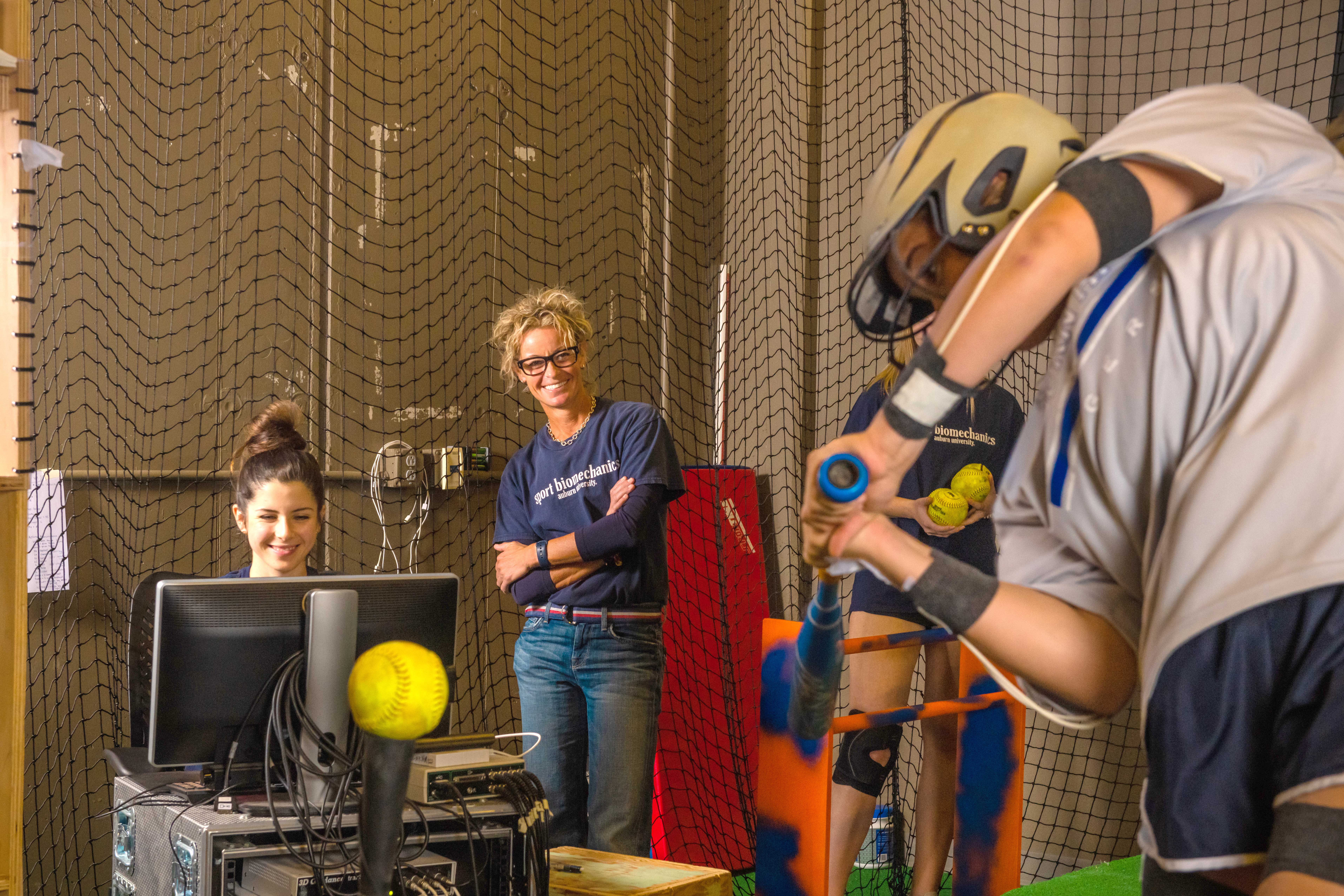 Students work with a baseball player in a lab