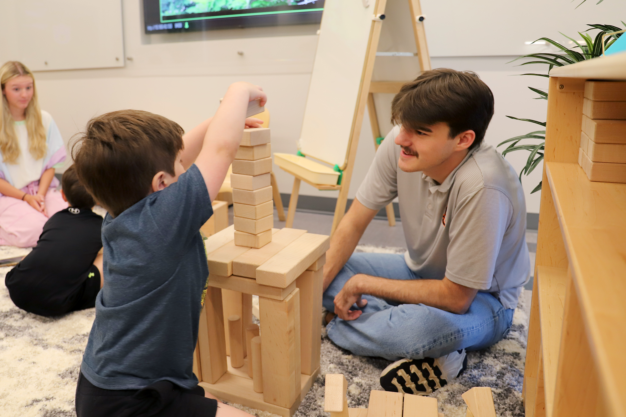 A student teacher plays blocks with a child