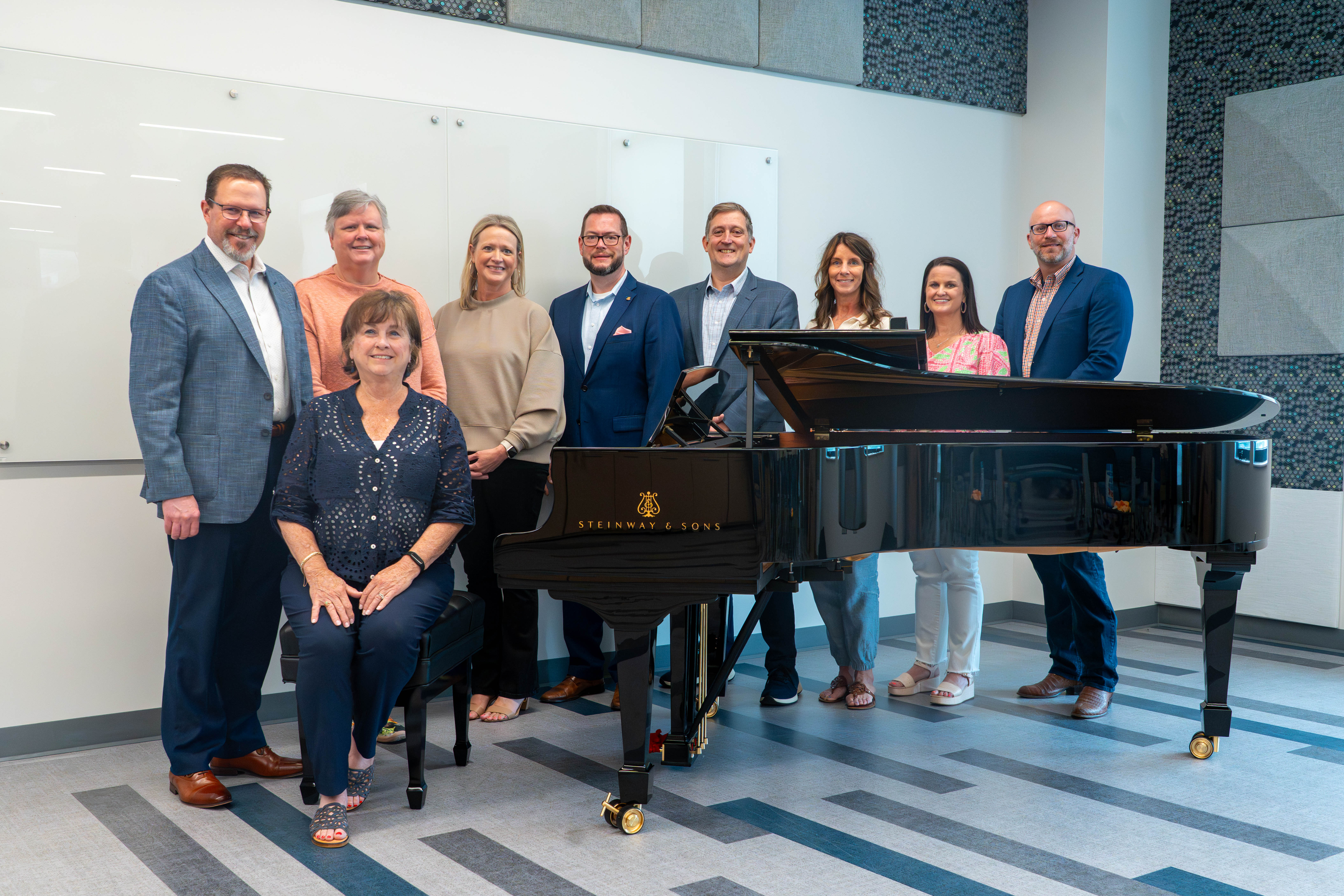 College of Education stakeholders, including the dean, advancement employees, music education faculty, and alumni pictured with the piano.