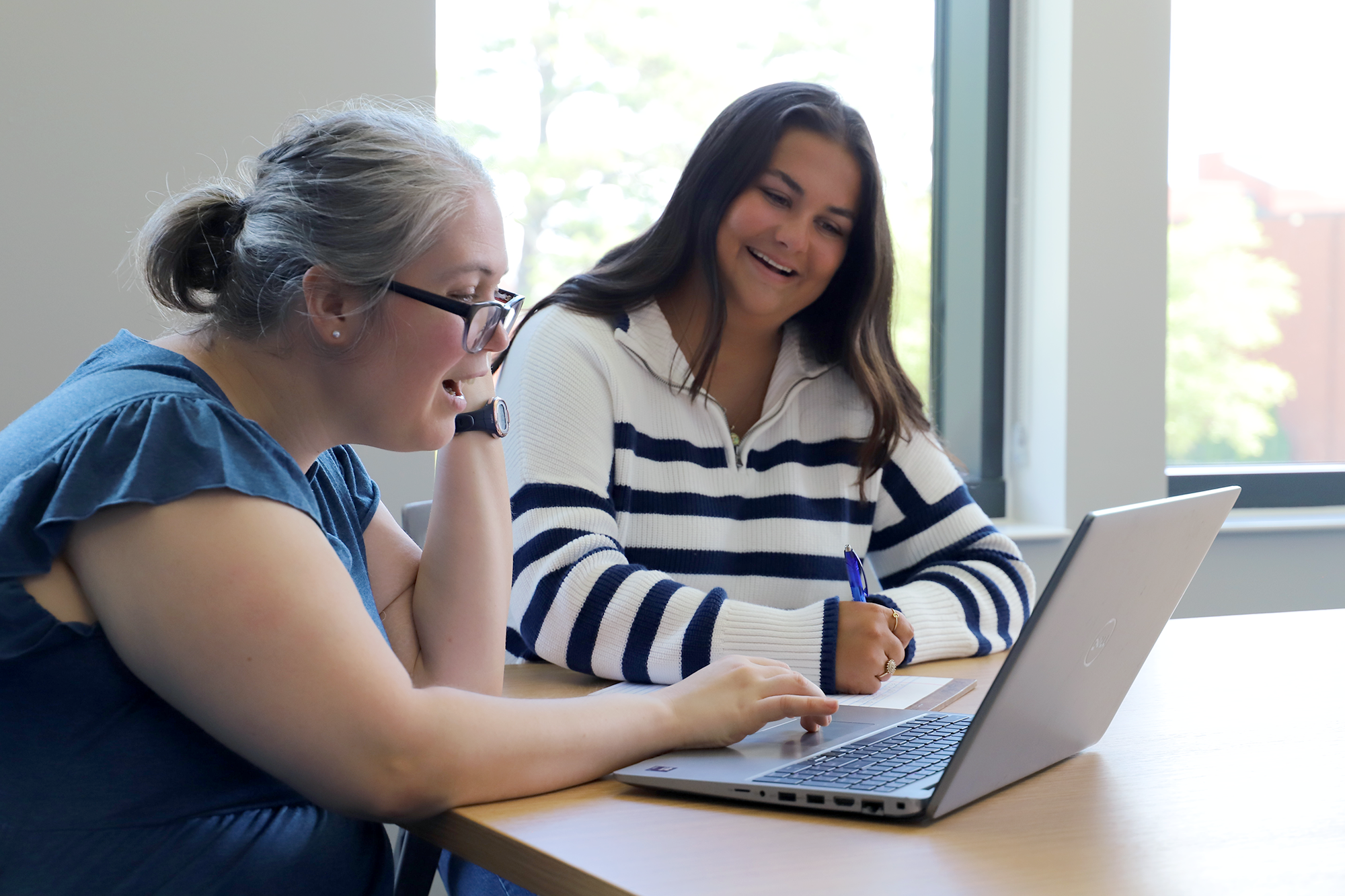 A teacher works with a student