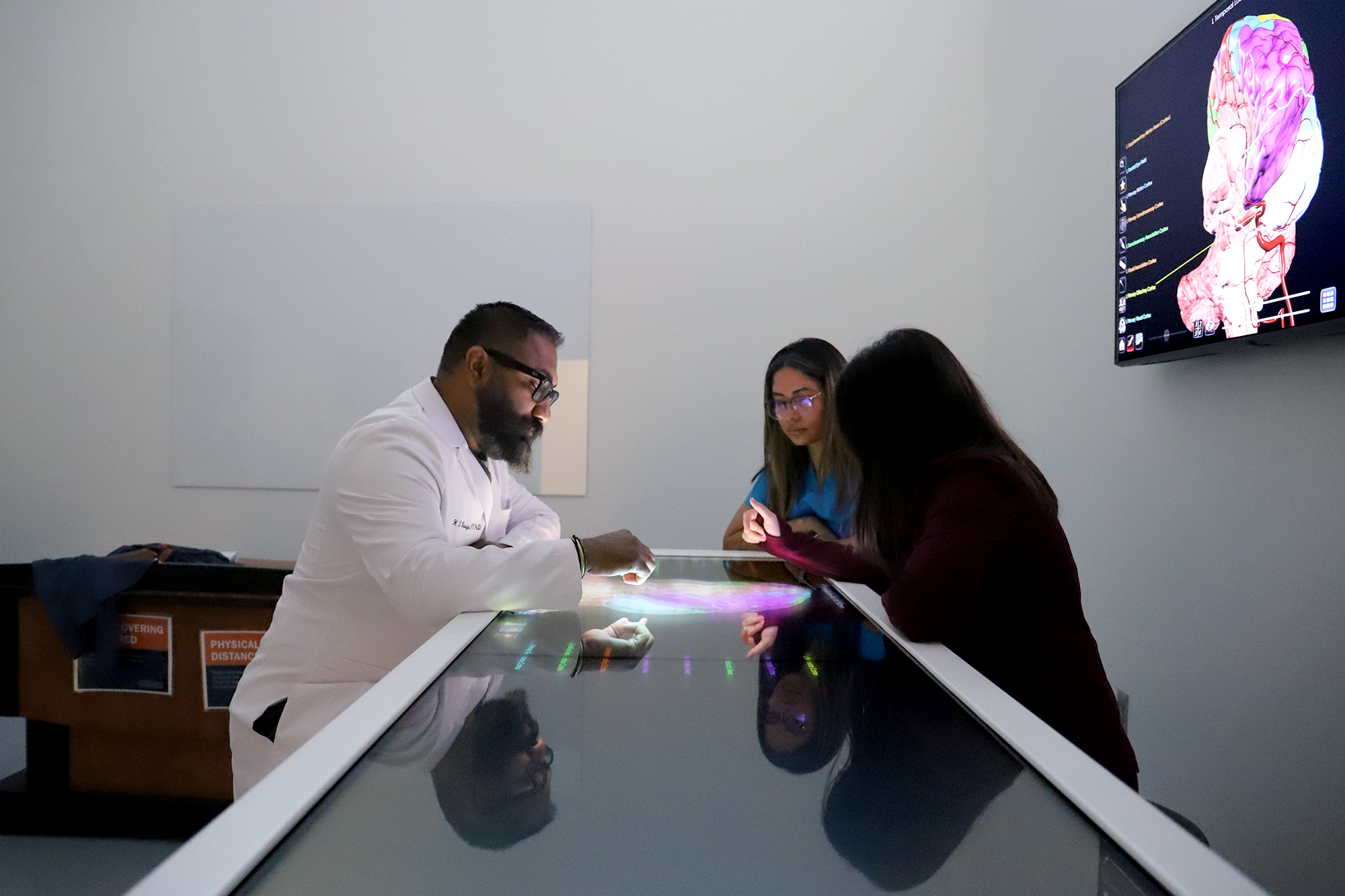 Students working on a digital anatomy table.
