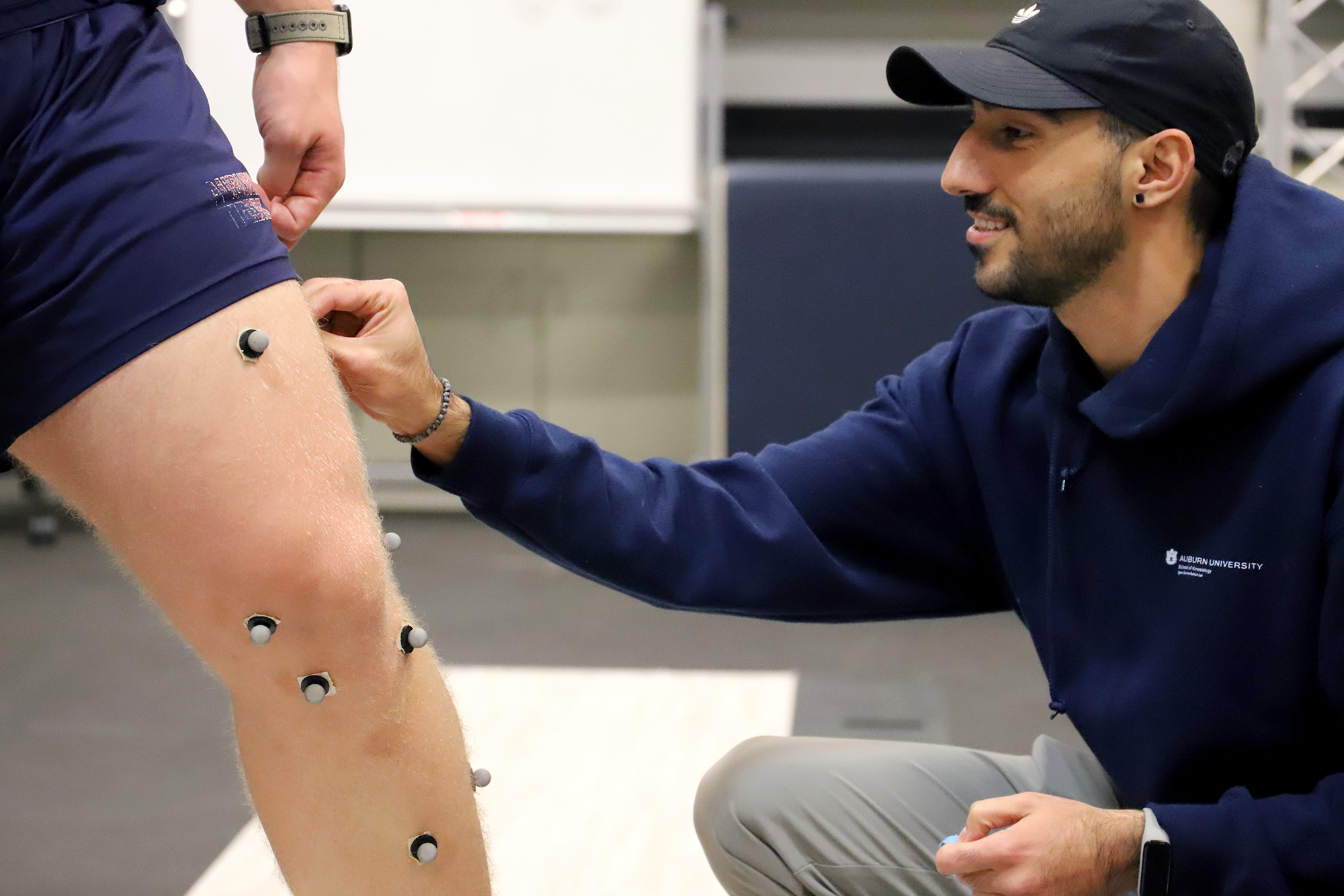 A student putting motion markers on a research participant.