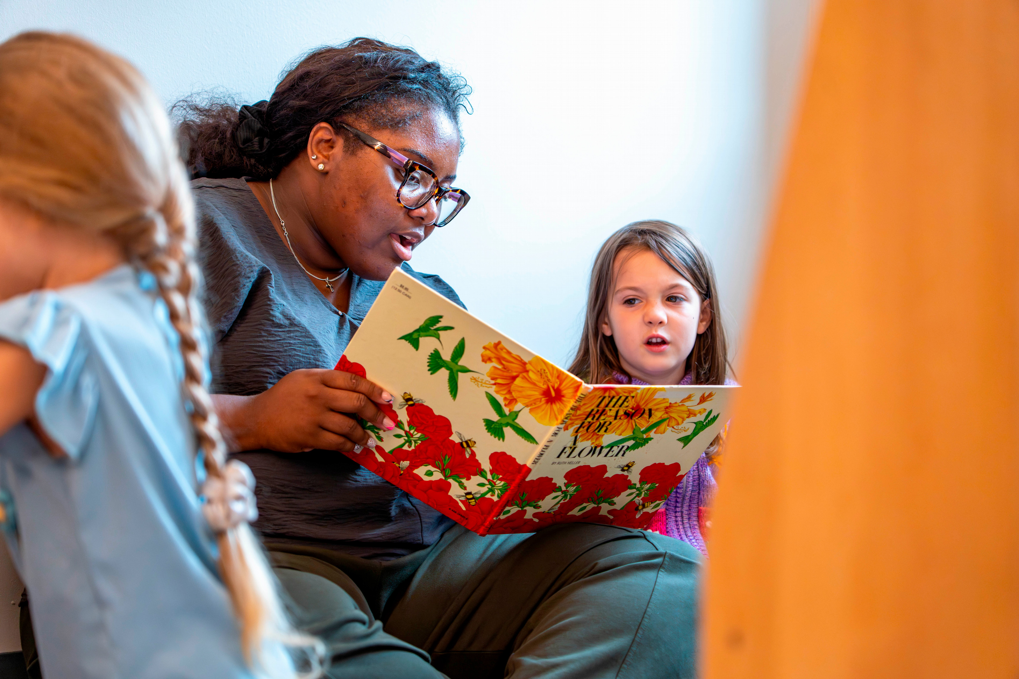 a preservice teacher reads to a student at summer enrichment camp