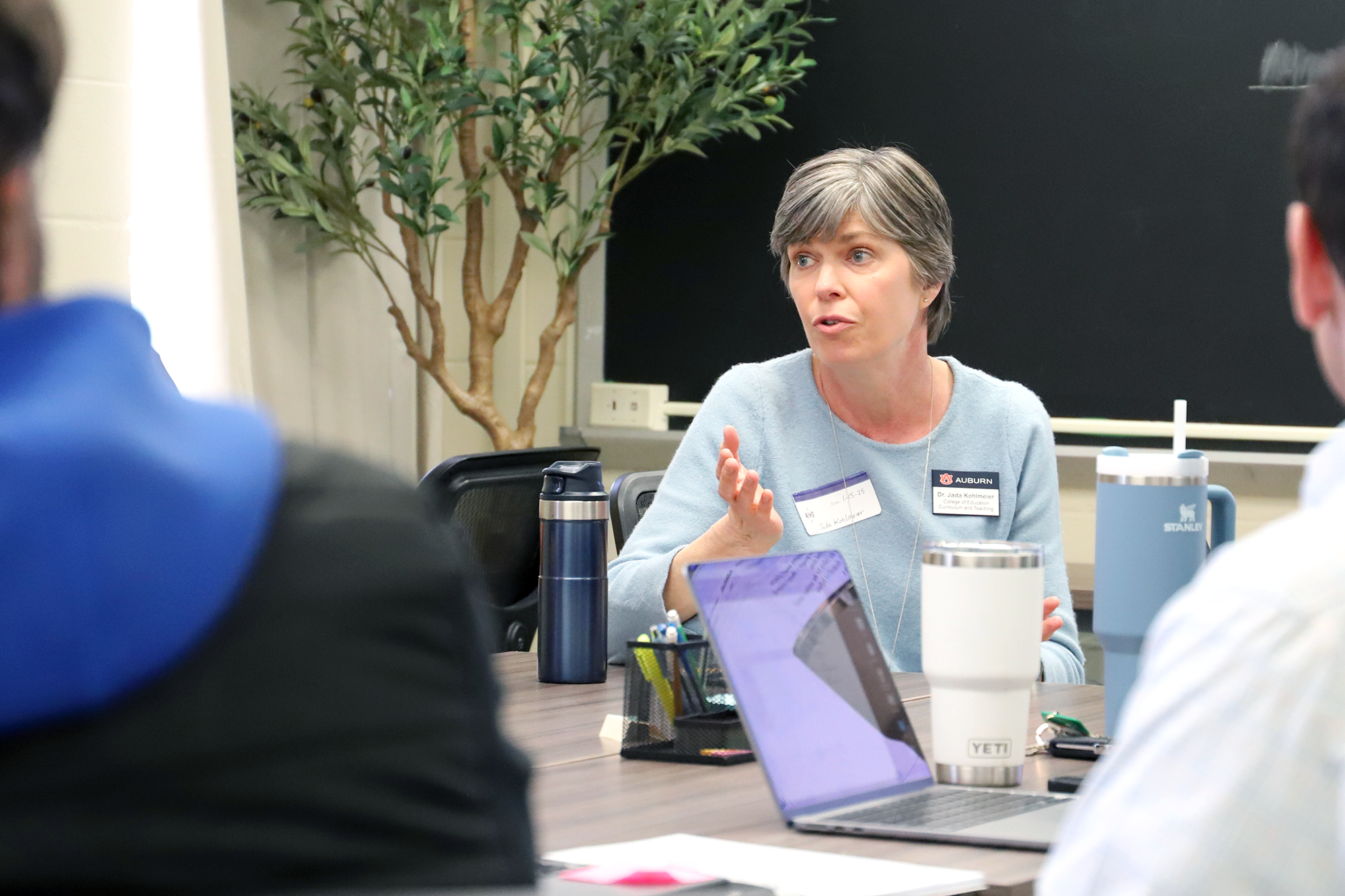 A faculty member holds a discussion with a group of students.