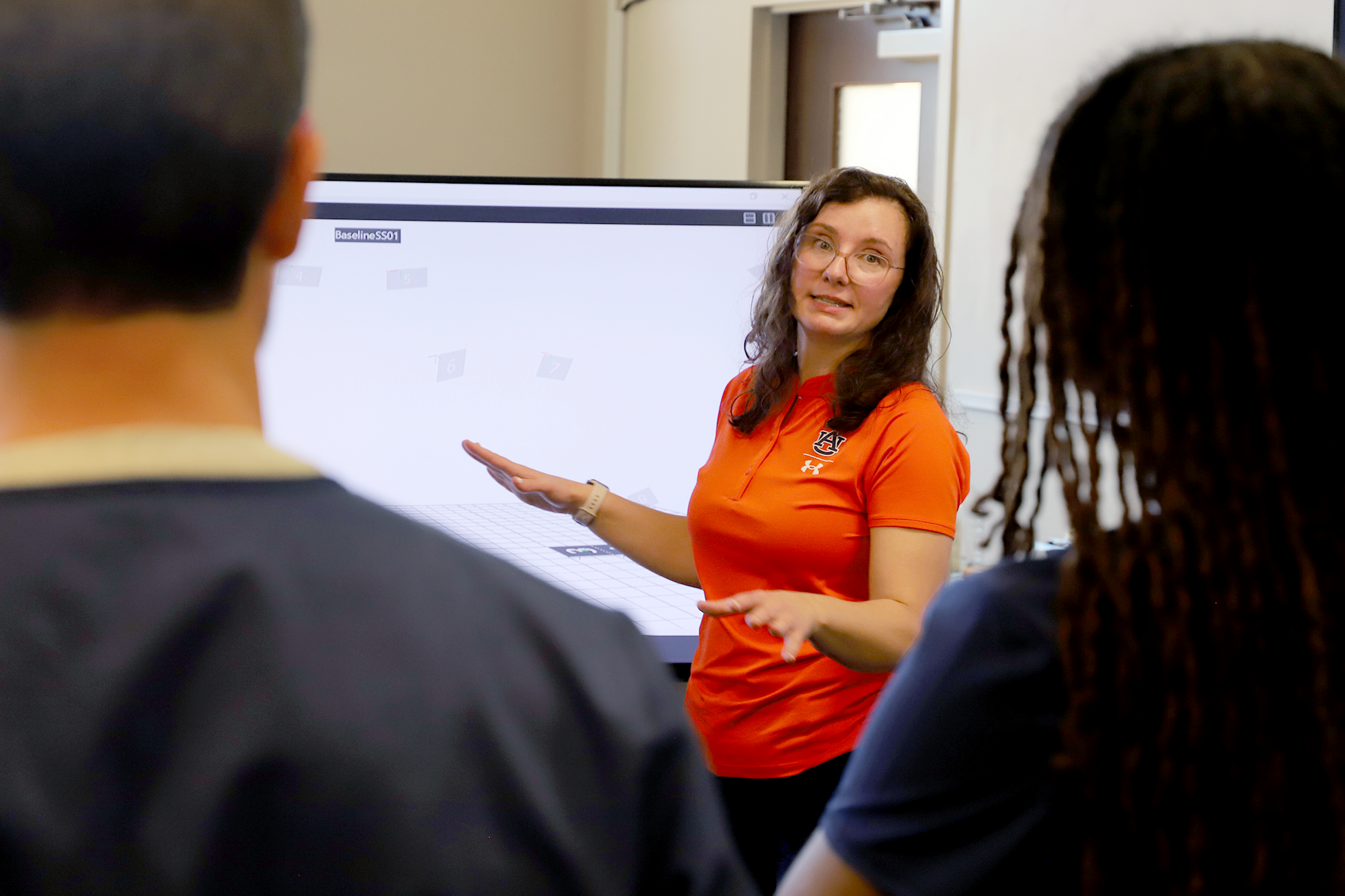 A faculty member discusses her research with several students